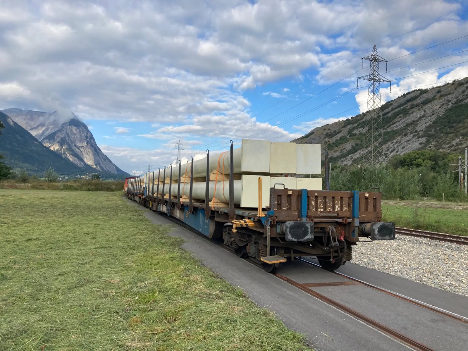 Tren de carga con tubería de acero rumbo a Turtmann, en los Alpes suizos
